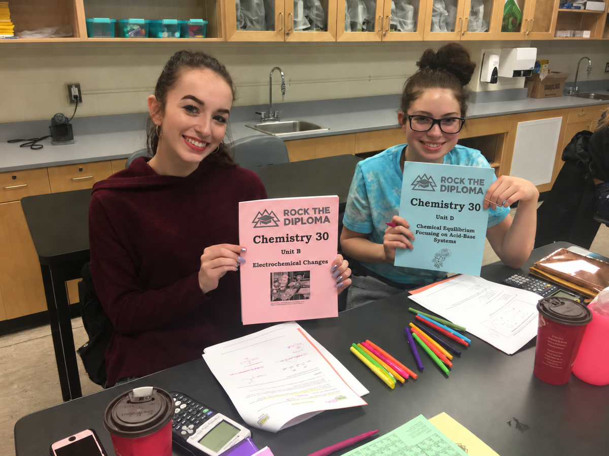 Smiling lab students with grayscale Chemistry booklets — SAIT, Calgary